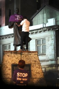 an activist dressed up the statue of Gandhi at the Joburg CBD whilst the other one looked on